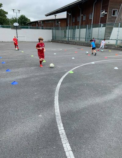 Kids play football on outdoor pitch