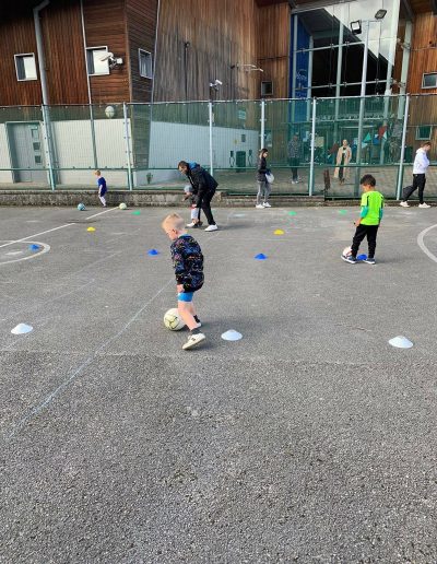 Kids play football on outdoor pitch