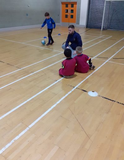 Kids play football in indoor pitch