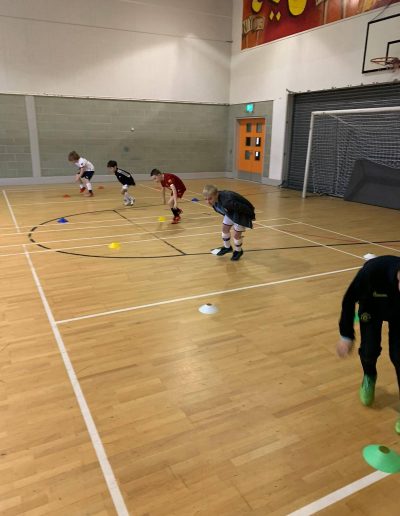Kids play football in indoor pitch